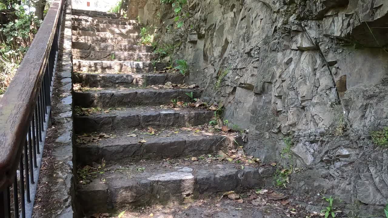 爬楼梯在中世纪的城市，古老的古楼梯附近的石崖。视频素材