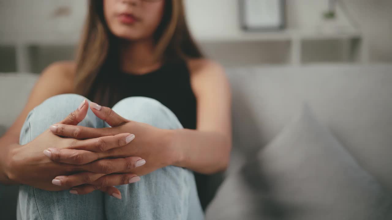 在客厅里孤独地经历精神痛苦的年轻女子视频素材