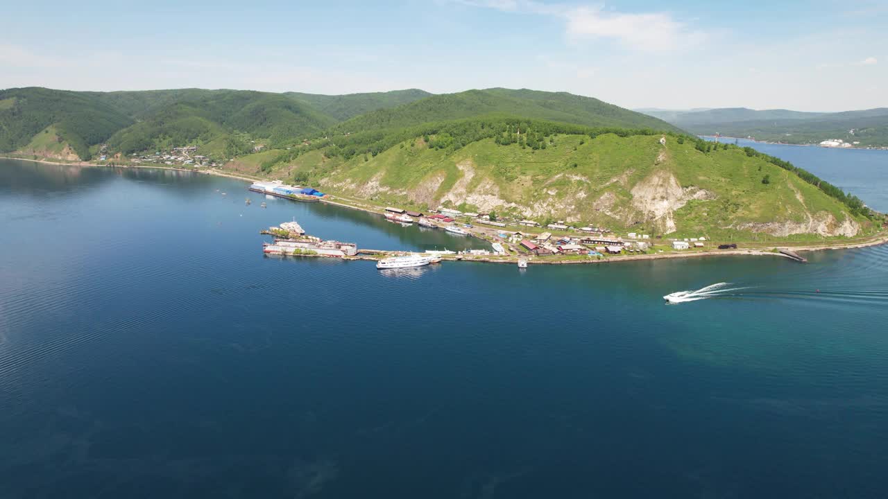 从空中俯瞰贝加尔湖港口。一艘载着游客的船沿着贝加尔湖行驶。视频素材