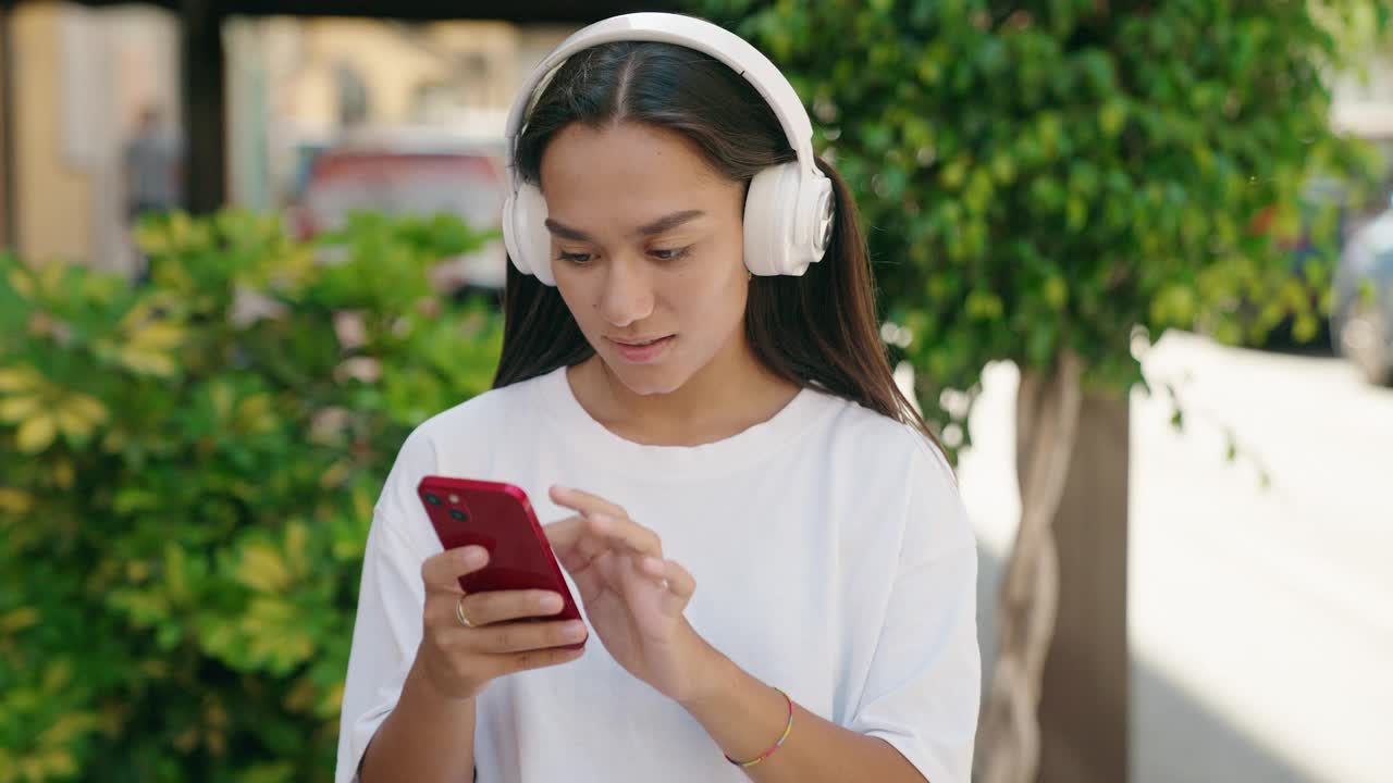 年轻美丽的西班牙女子在街上听音乐跳舞视频素材