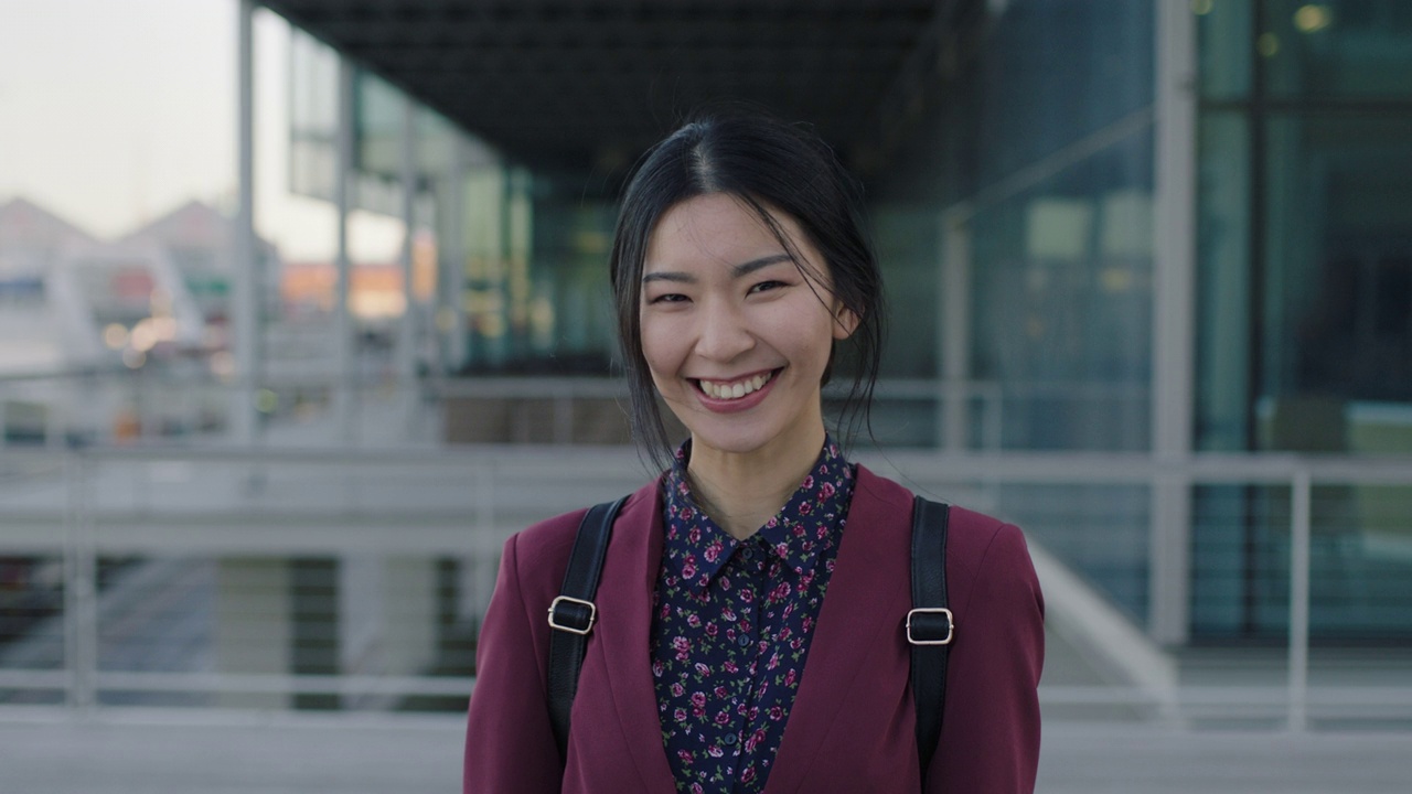 年轻的亚洲女学生站在大学校园开心地笑着视频素材