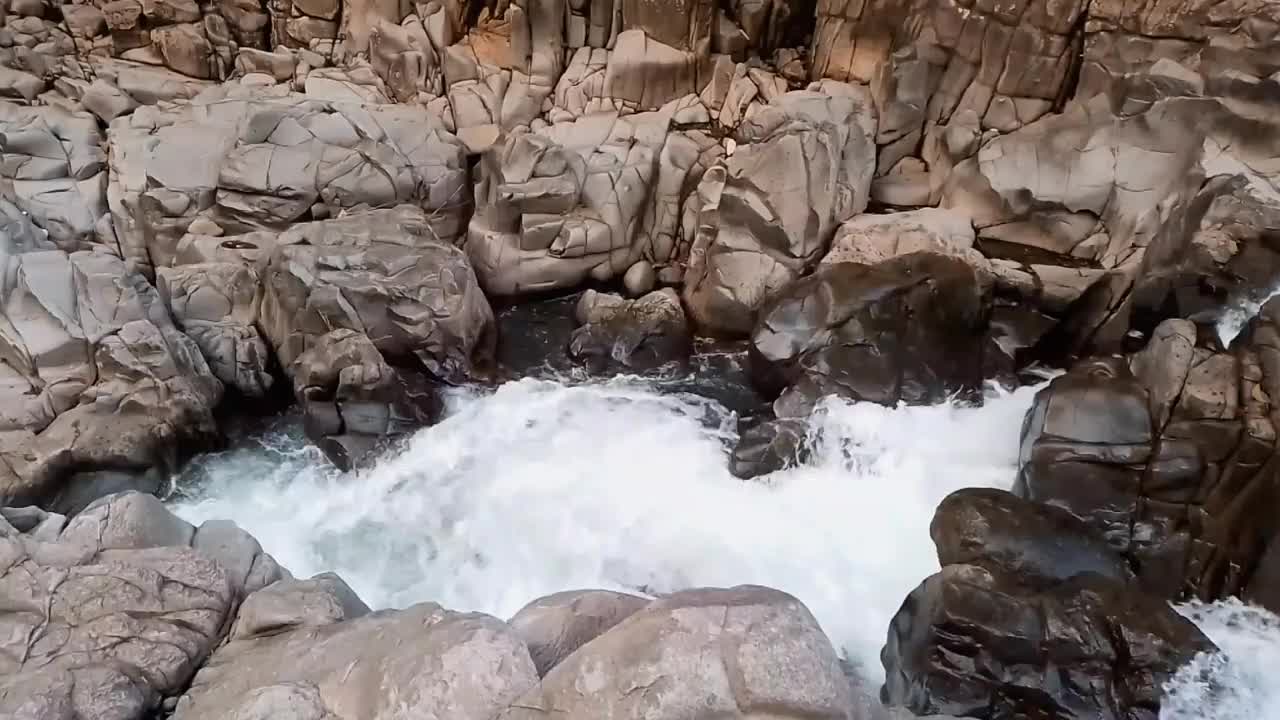 河水在有很多岩石的河流中迅速流动。它位于印度尼西亚南苏拉威西岛巴鲁的西里伯斯峡谷。新鲜的水!静态视频。视频下载