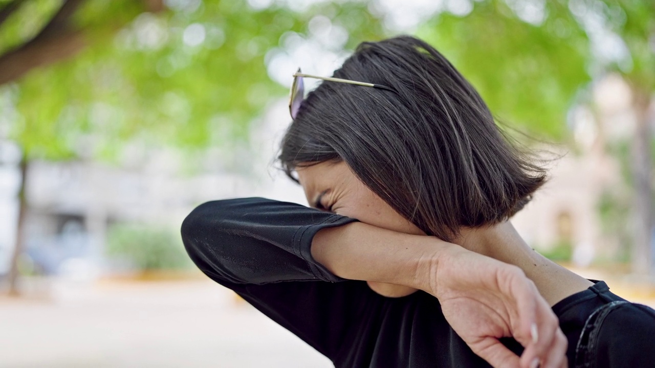 年轻漂亮的西班牙女人在公园里打喷嚏视频素材