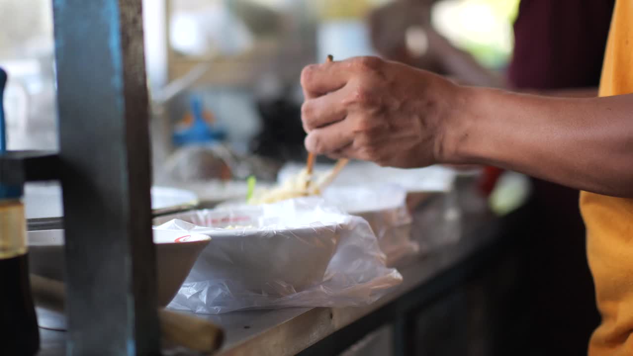 准备鸡肉面。正在为买家制作鸡肉面的肉丸鸡面卖家。有选择性的重点。视频素材