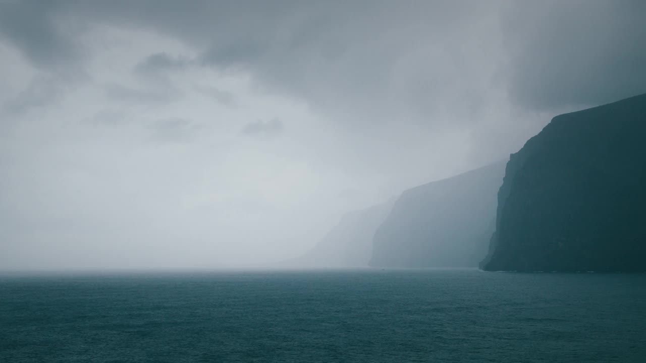 多岩石的海边，暴风雨的天气，海浪在灰色的多云的天空下。深色海洋景观视频素材