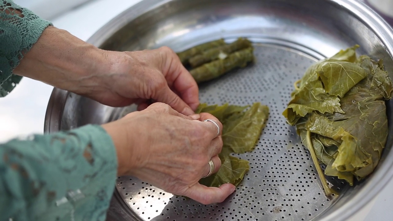 特写镜头:双手在葡萄叶上准备食物视频下载