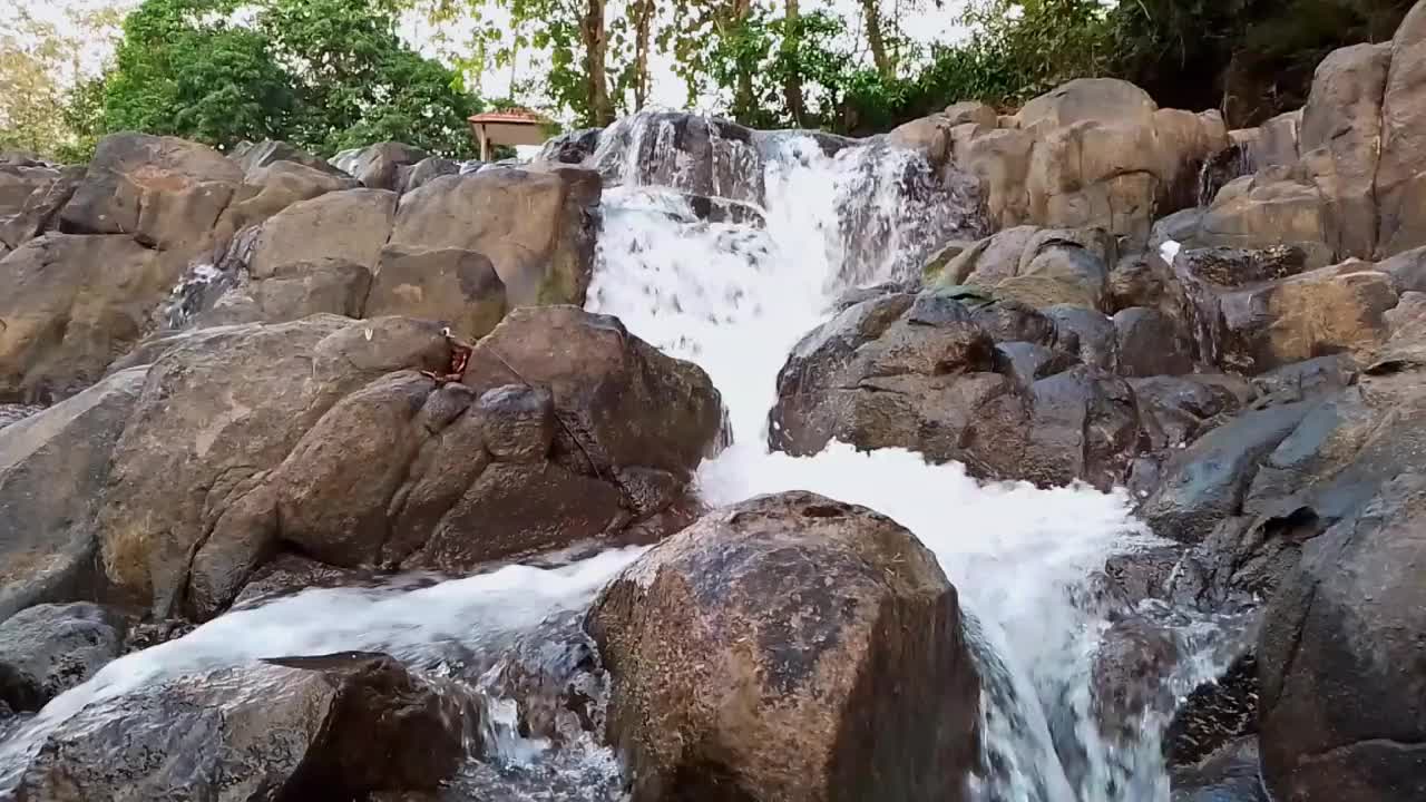 河水在有很多岩石的河流中迅速流动。它位于印度尼西亚南苏拉威西岛巴鲁的西里伯斯峡谷。新鲜的水!静态视频。视频下载