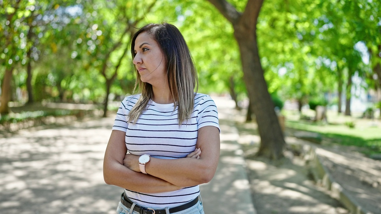 一位中东妇女在公园里双手交叉地看表视频素材