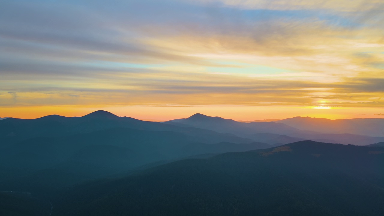 鸟瞰图，日落时，黑暗的山与明亮的夕阳。黄昏朦胧的山峰和朦胧的山谷视频素材