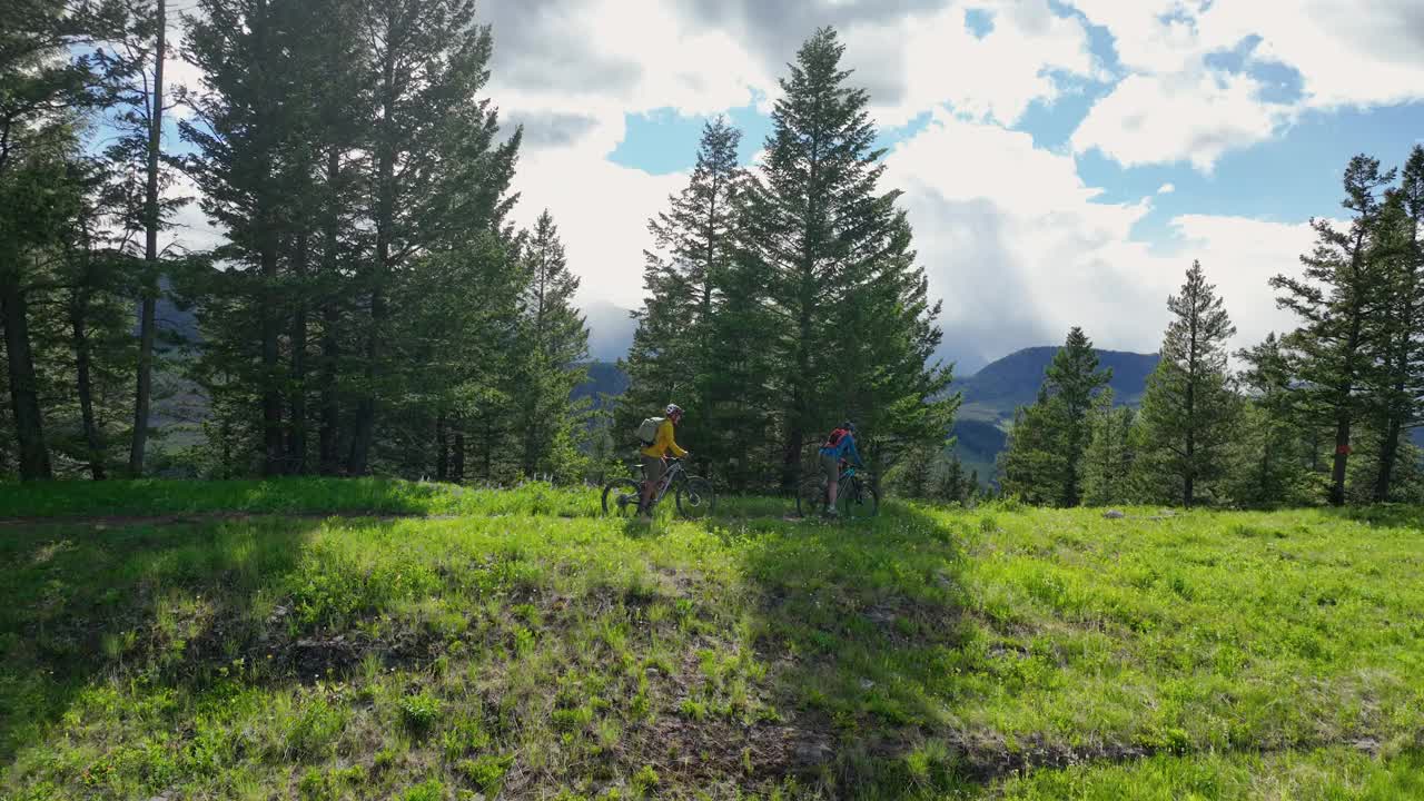 空中视角的山地自行车骑在郁郁葱葱的山脊视频下载