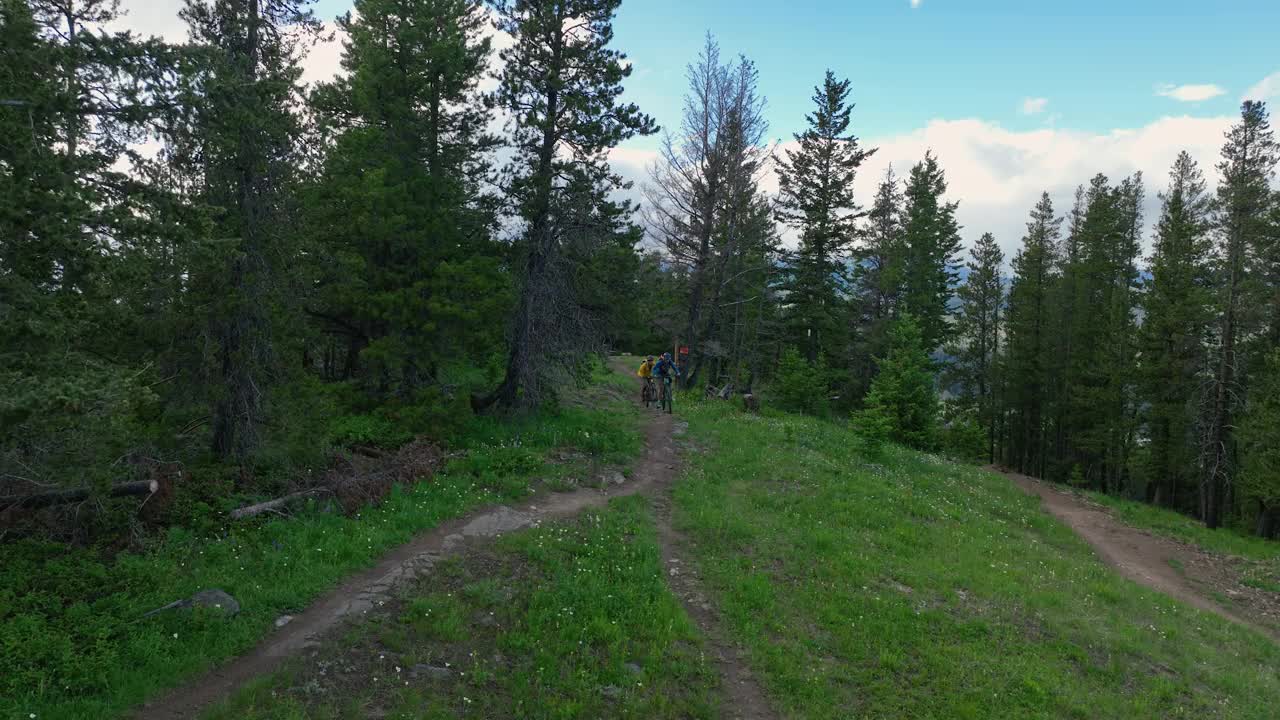 空中视角的山地自行车骑在郁郁葱葱的山脊视频下载