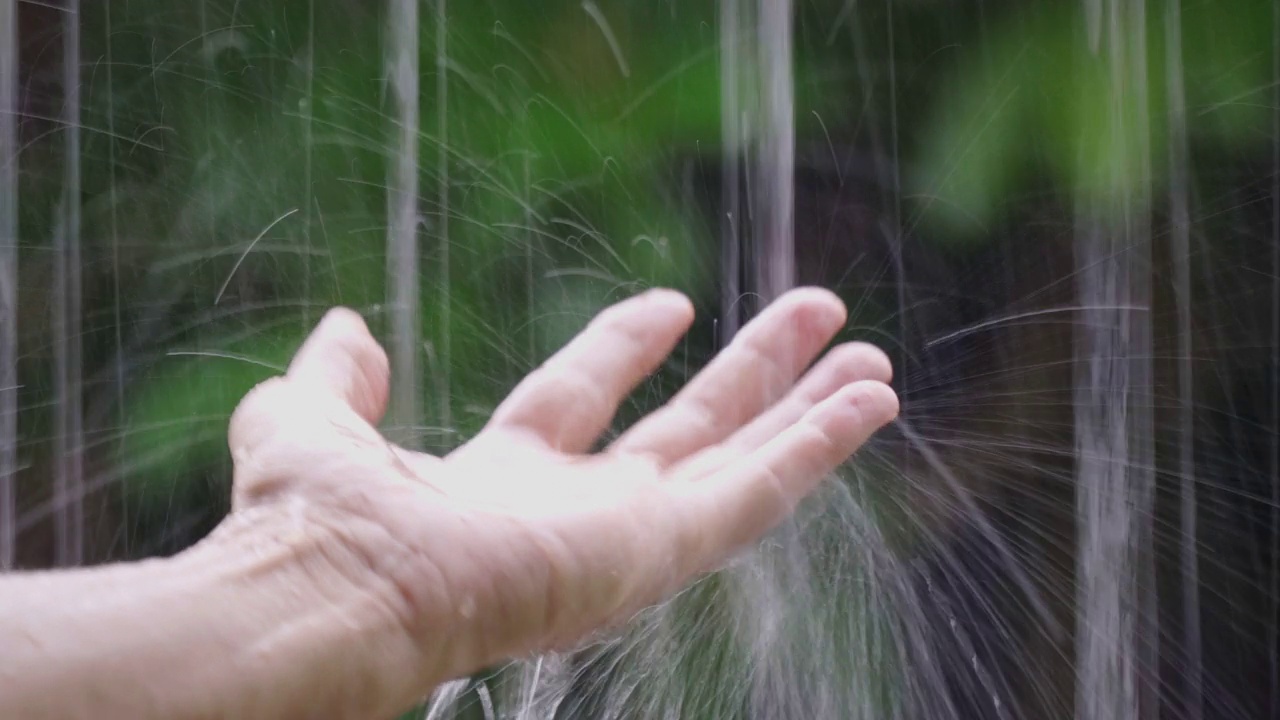 男子用手触摸屋顶上的雨水视频素材