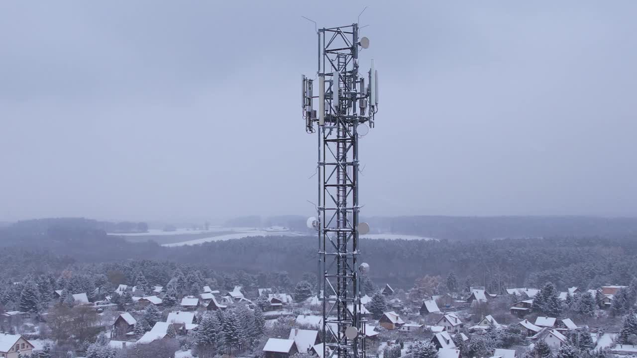 塔式天线电信手机鸟瞰图，蜂窝5g 4g手机无线电发射机。提供高速现代5g通信网服务。雪自然森林冬季。视频素材