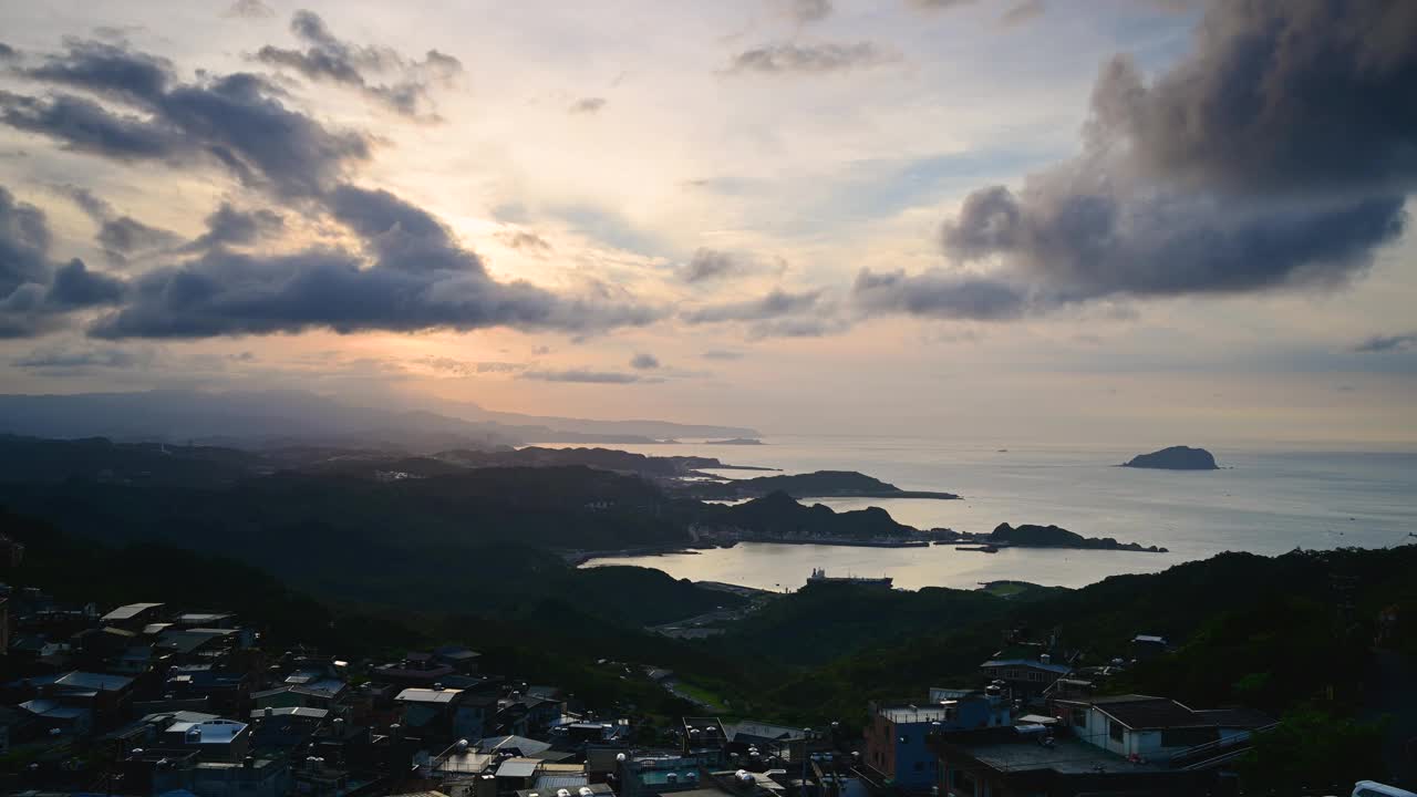 一个四面环山和大海的村庄。蓝天和五彩缤纷的动态云。视频素材