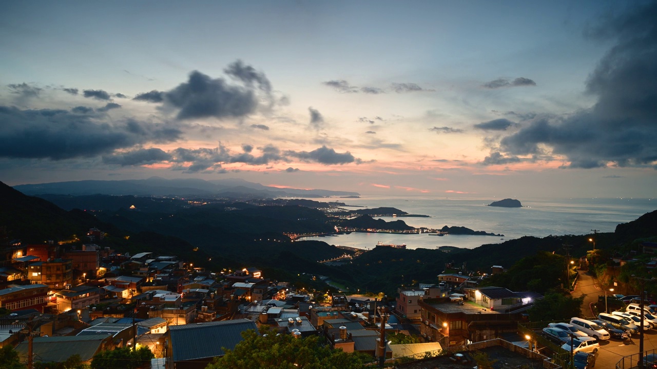 一个四面环山和大海的村庄。蓝天和五彩缤纷的动态云。视频素材