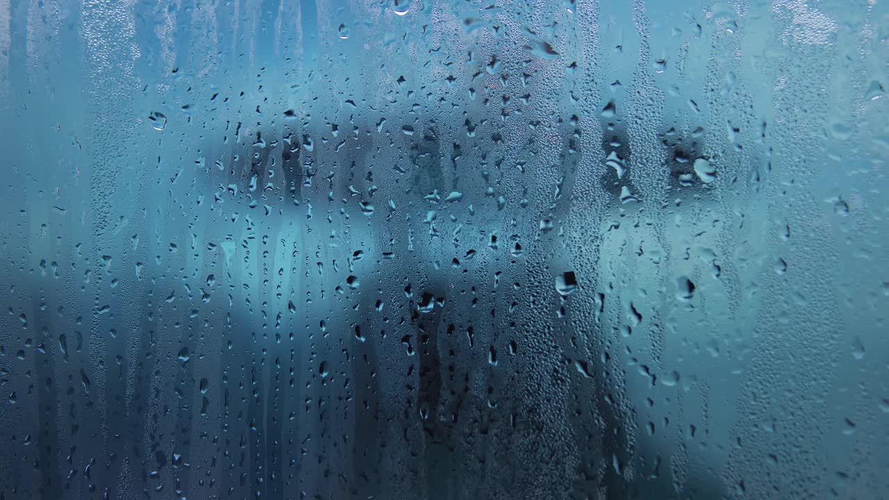 大雨过后，男性白种人手指在窗户上画心的特写视频素材