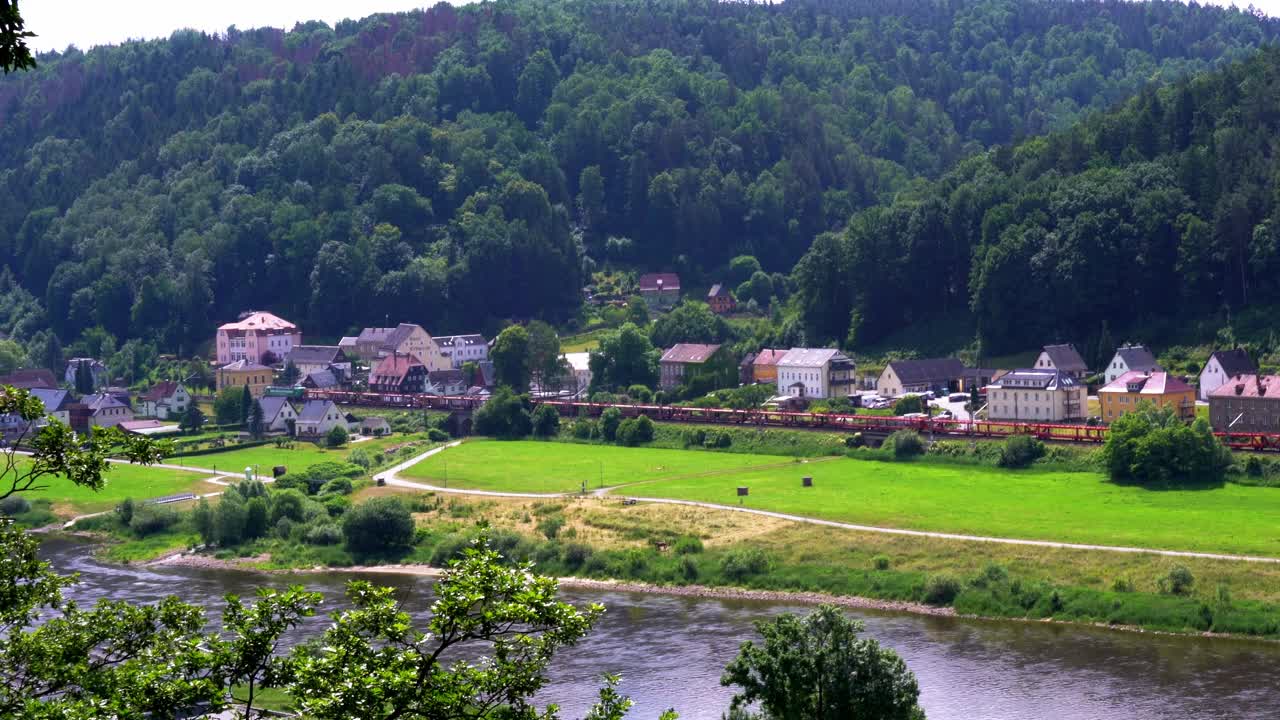 在德国，撒克逊瑞士易北河砂岩山脉的易北河左侧的铁路线和街道村庄的视图视频素材