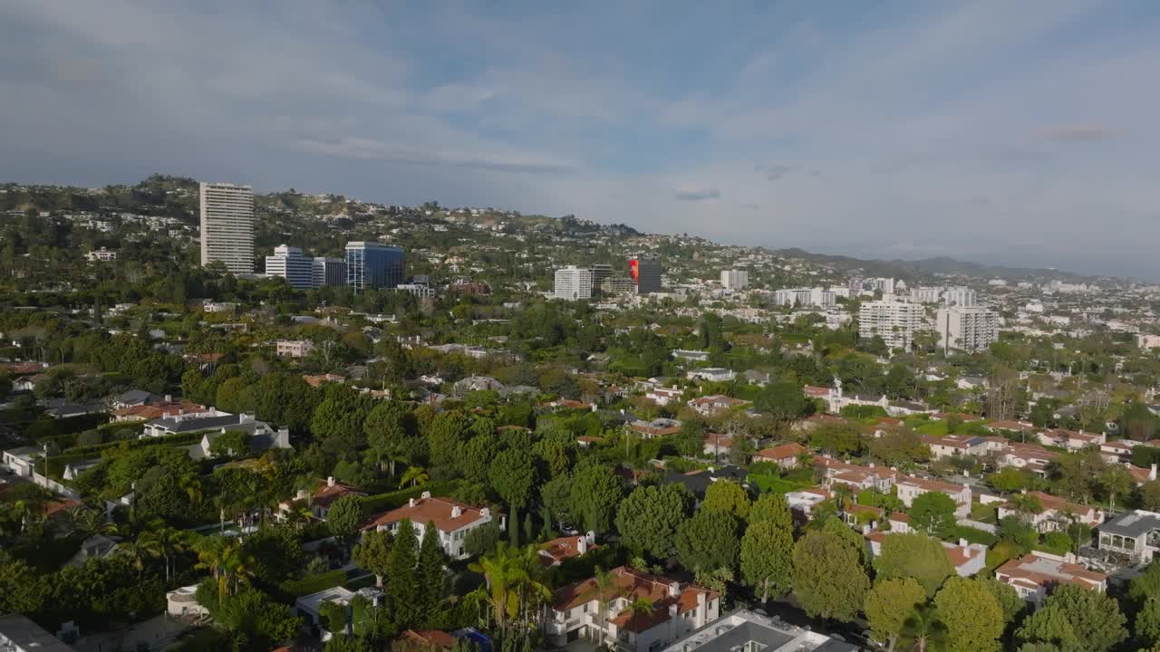 在黄金时段，飞机在城市的住宅区上空飞行。房子和绿树。视频素材