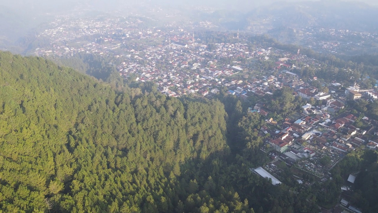 印尼村庄的早晨鸟瞰图，靠近山，有雾的景色和阳光光束。神奇的观点视频素材