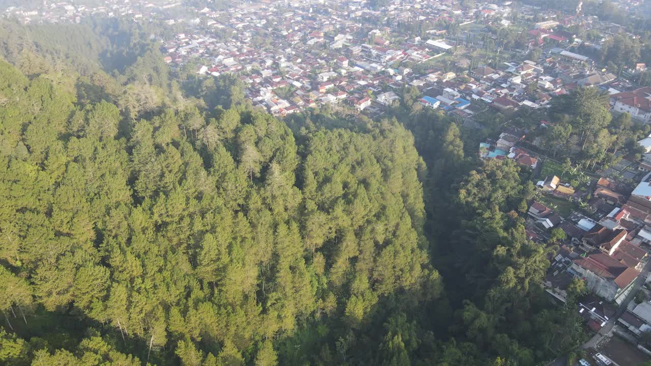 印尼村庄的早晨鸟瞰图，靠近山，有雾的景色和阳光光束。神奇的观点视频素材