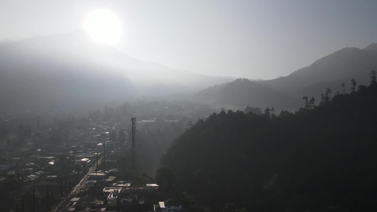 印尼村庄的早晨鸟瞰图，靠近山，有雾的景色和阳光光束。神奇的观点视频素材