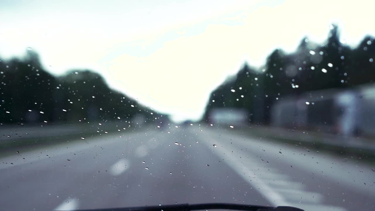 雨点落在挡风玻璃上。雨刷操作视频素材