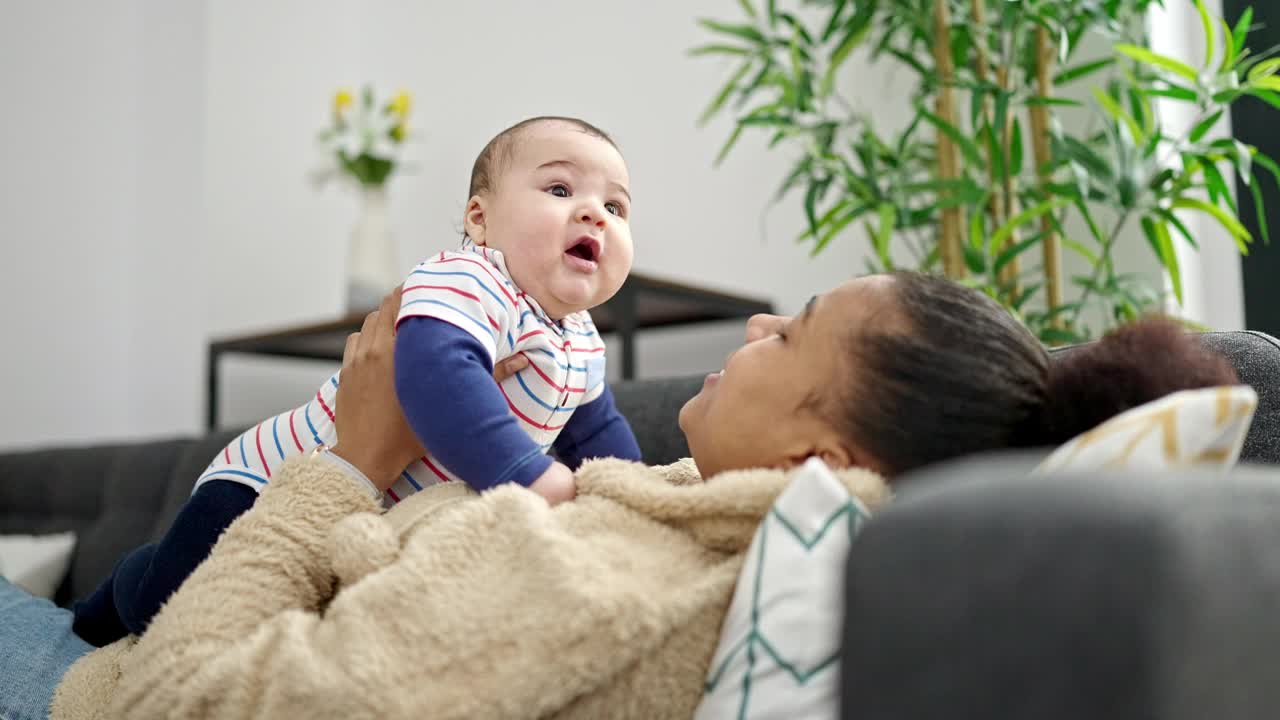 母子俩抱着躺在家里沙发上的婴儿视频素材