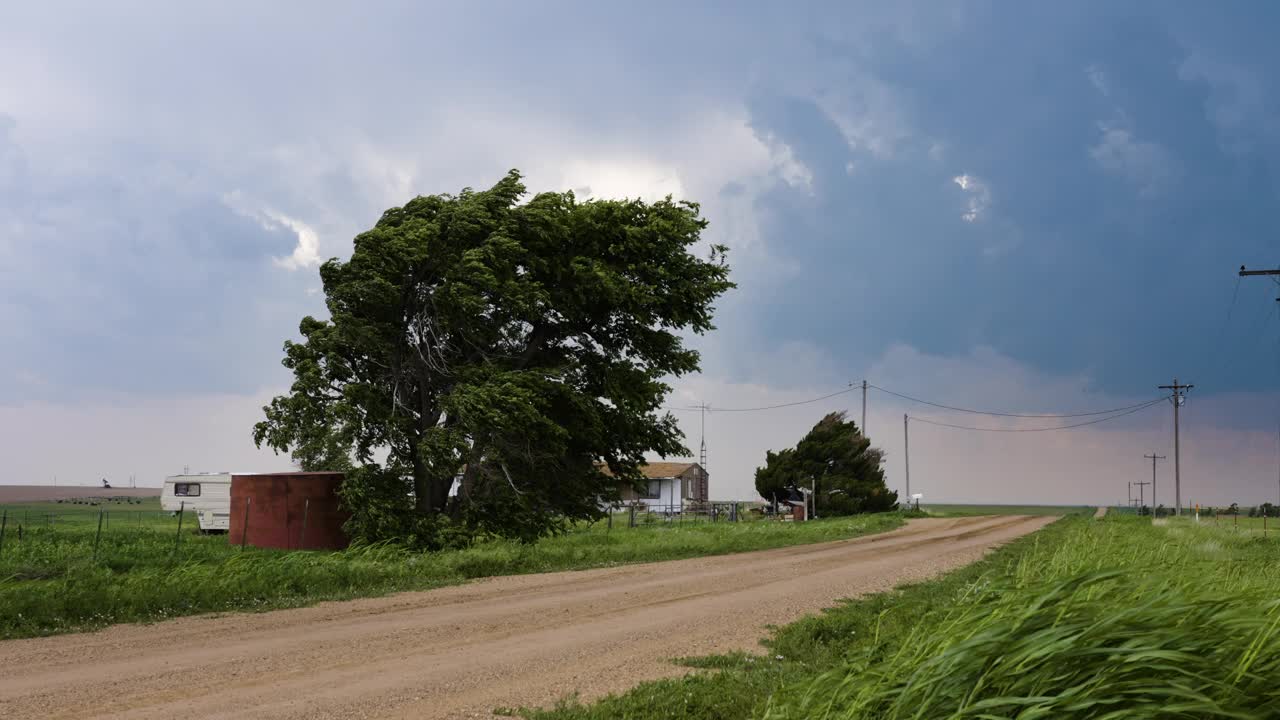 尘土飞扬的道路上的小房子，狂风暴雨的天空视频素材