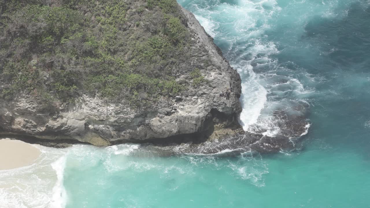 巴厘岛努沙Penida印度尼西亚-渔民捕鱼在蓝色的水，巨大的海浪，强烈的潮汐击中岩石，危险而美丽的海洋视频素材