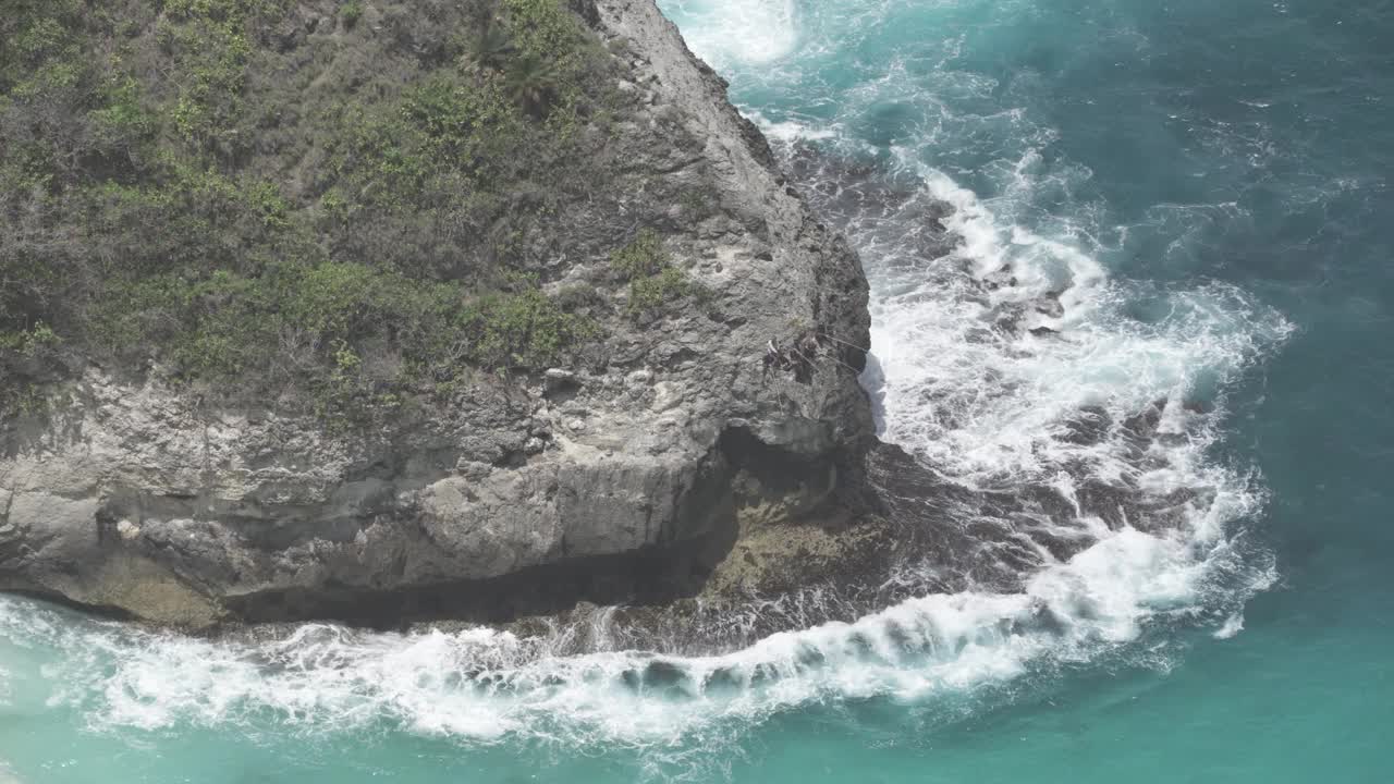 巴厘岛努沙Penida印度尼西亚-渔民捕鱼在蓝色的水，巨大的海浪，强烈的潮汐击中岩石，危险而美丽的海洋视频素材