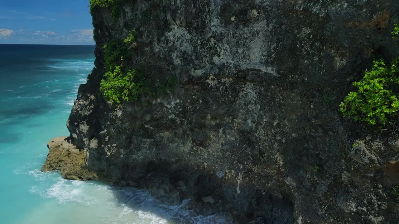 巴厘岛的热带海岸线有岩石和蓝色的海浪。鸟瞰图。视频素材