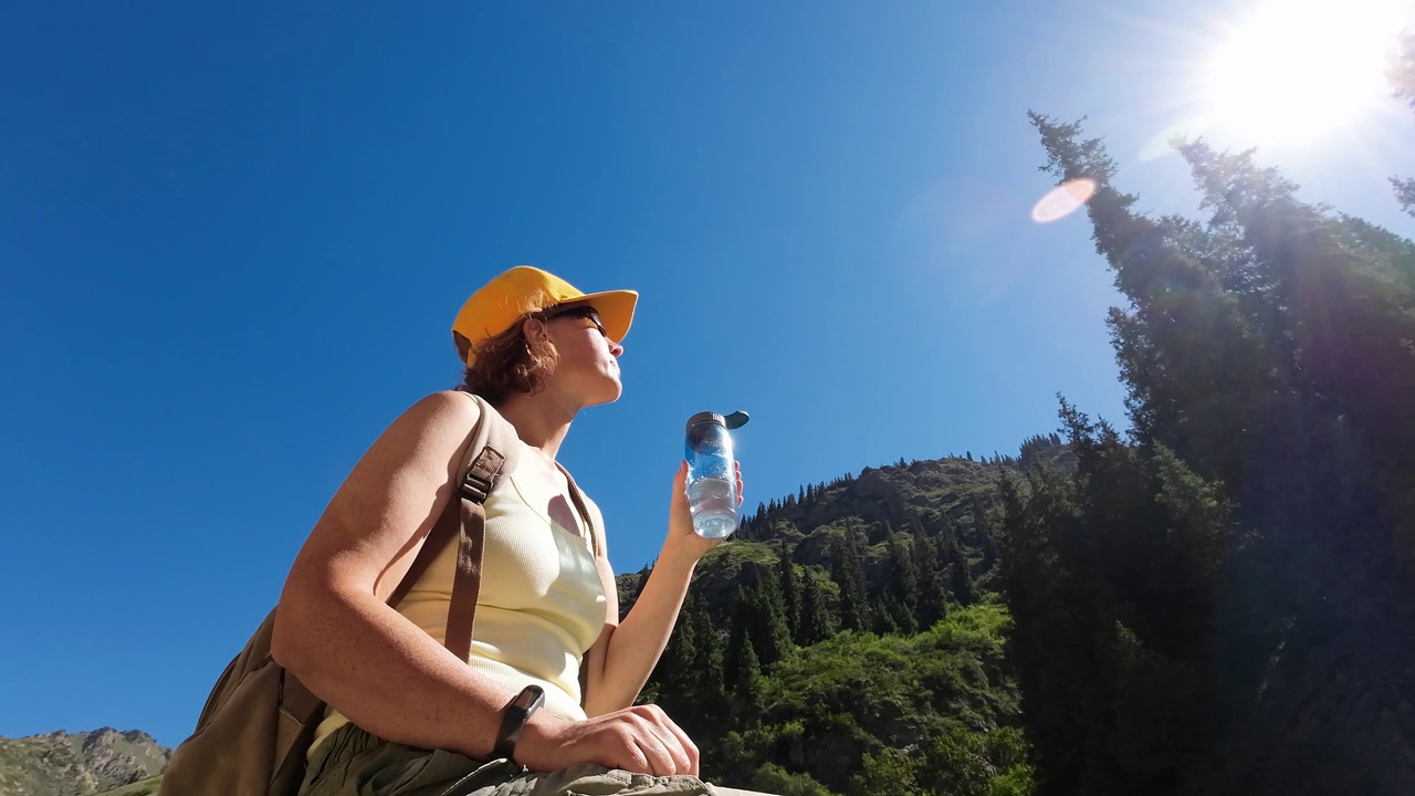 女游客在天山峡徒步旅行时正在喝水视频素材