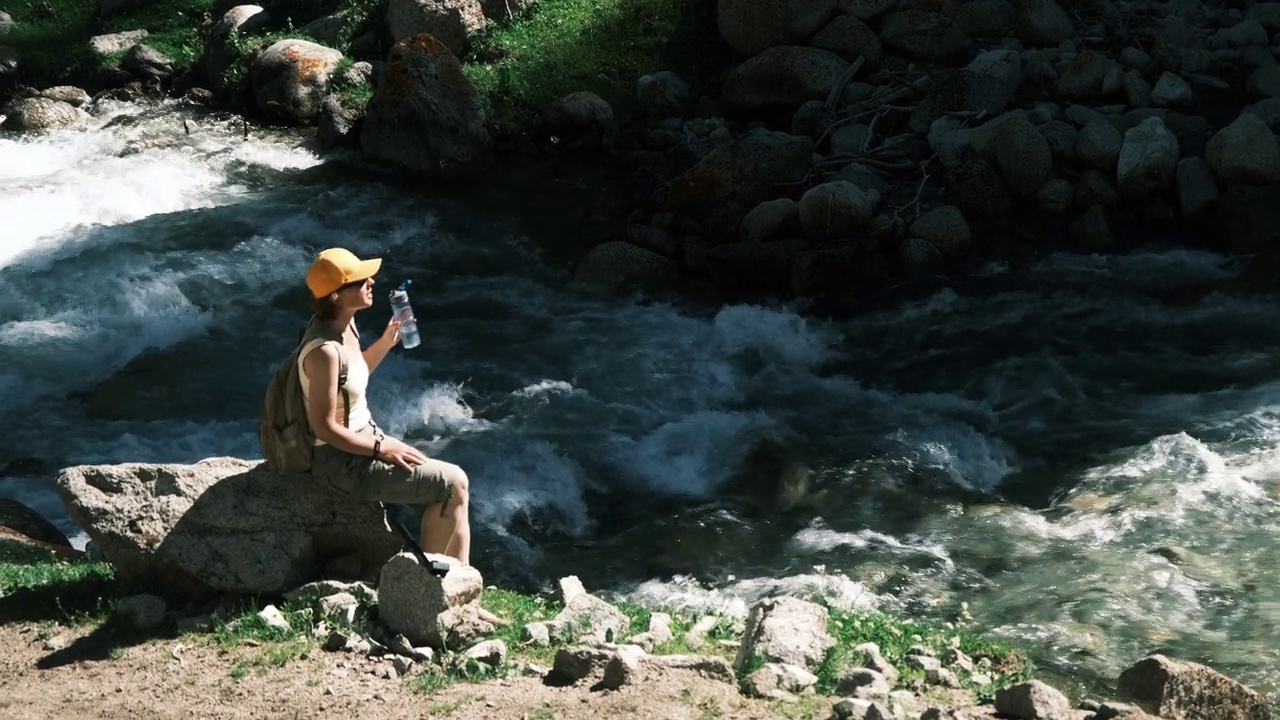 女游客在天山峡徒步旅行时正在喝水视频素材