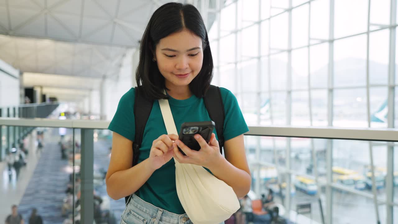 玩手机通讯，在候机楼内等候登机的女子旅行。视频素材