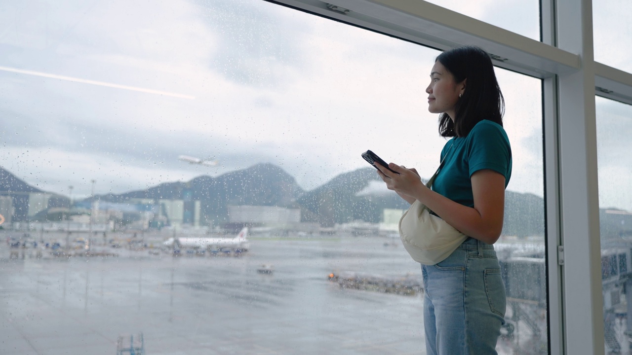 玩手机通讯，在候机楼内等候登机的女子旅行。视频素材