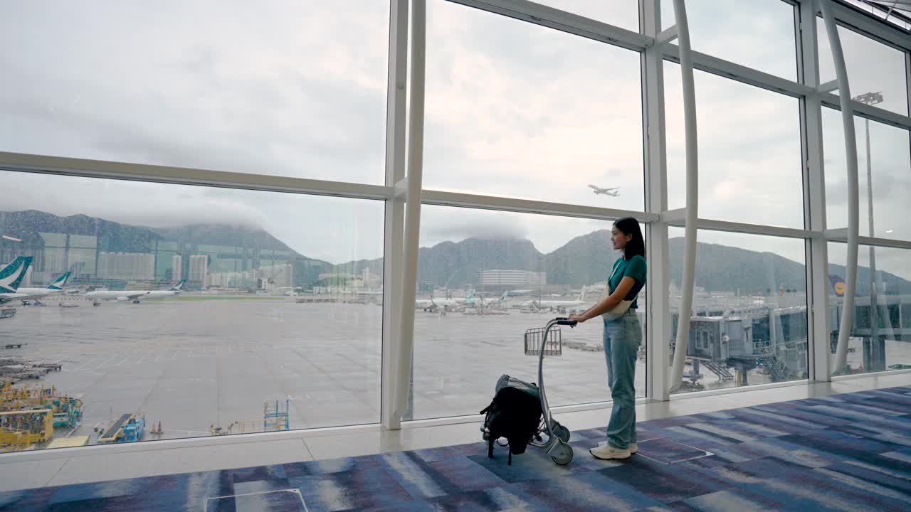 玩手机通讯，在候机楼内等候登机的女子旅行。视频素材