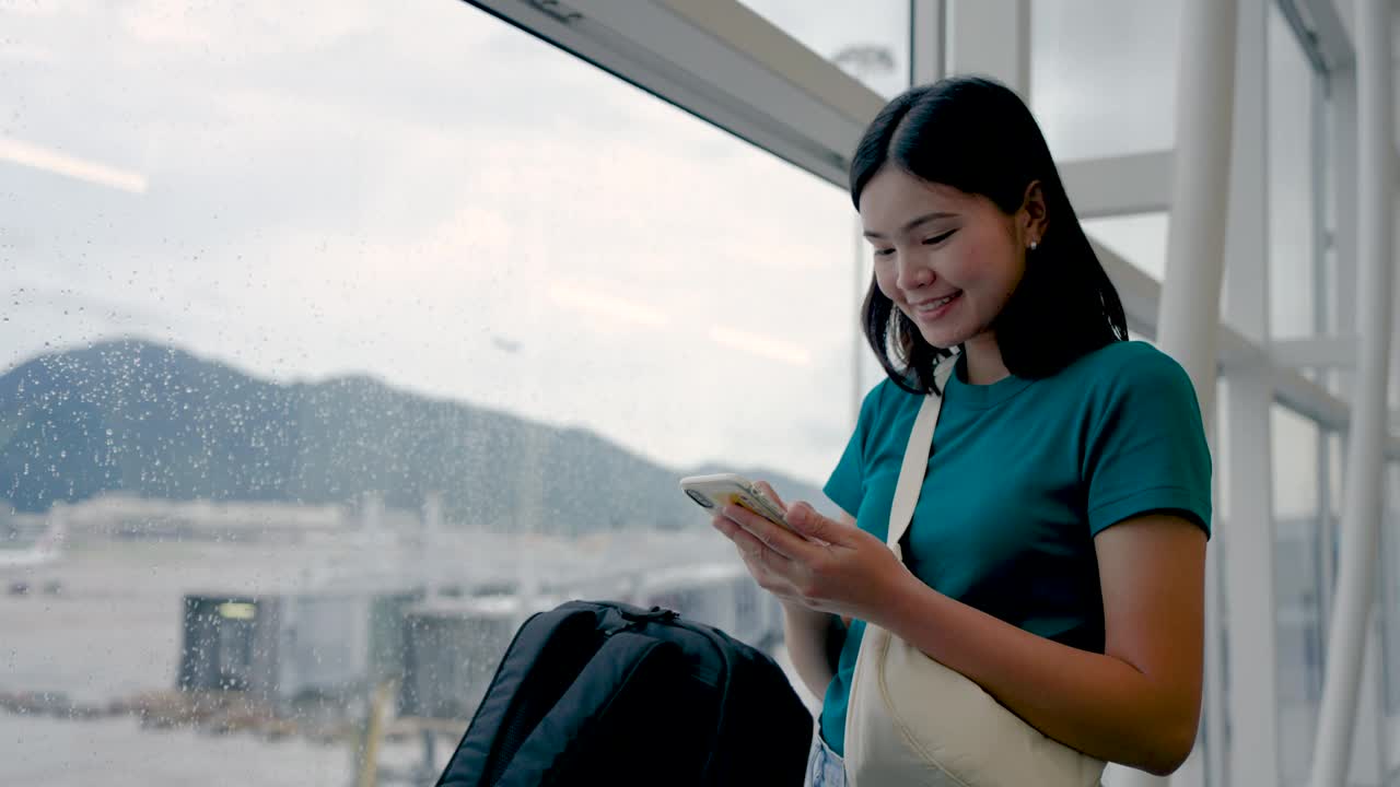 玩手机通讯，在候机楼内等候登机的女子旅行。视频素材