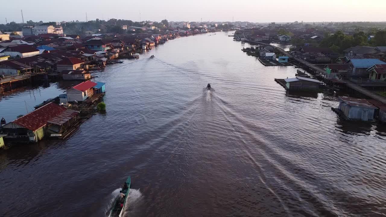 城市的鸟瞰图，它位于河岸上，船只在河上飞驰，船只用于运输。Pangkalanbun，婆罗洲中部。印度尼西亚——2023年7月10日视频素材