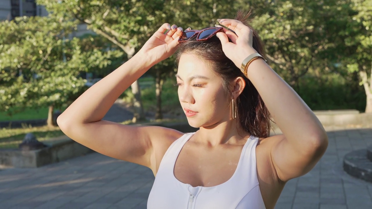 年轻的亚洲女子在阳光明媚的日子里戴着太阳镜。台北,台湾。视频素材