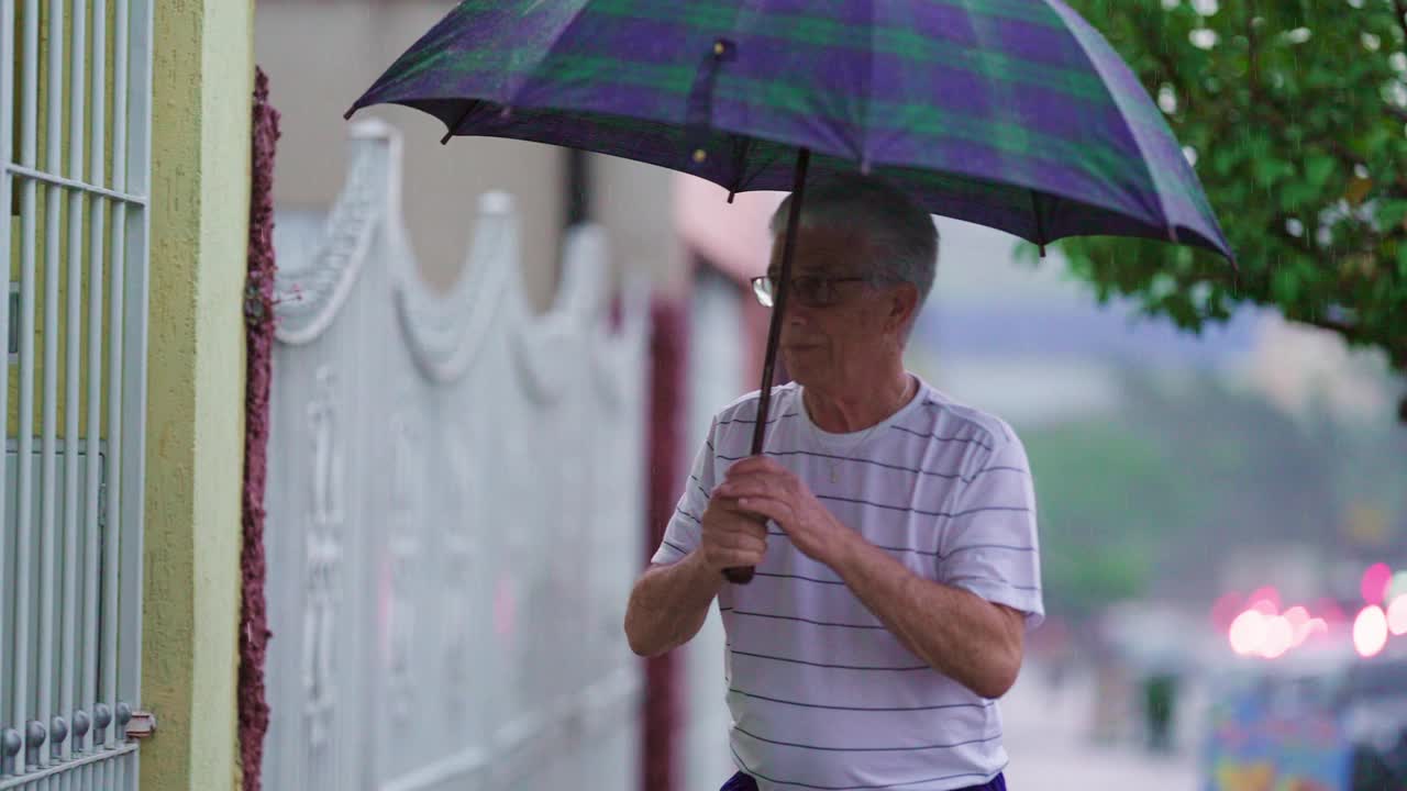 老人开门回家，下雨时有雨伞把守视频素材