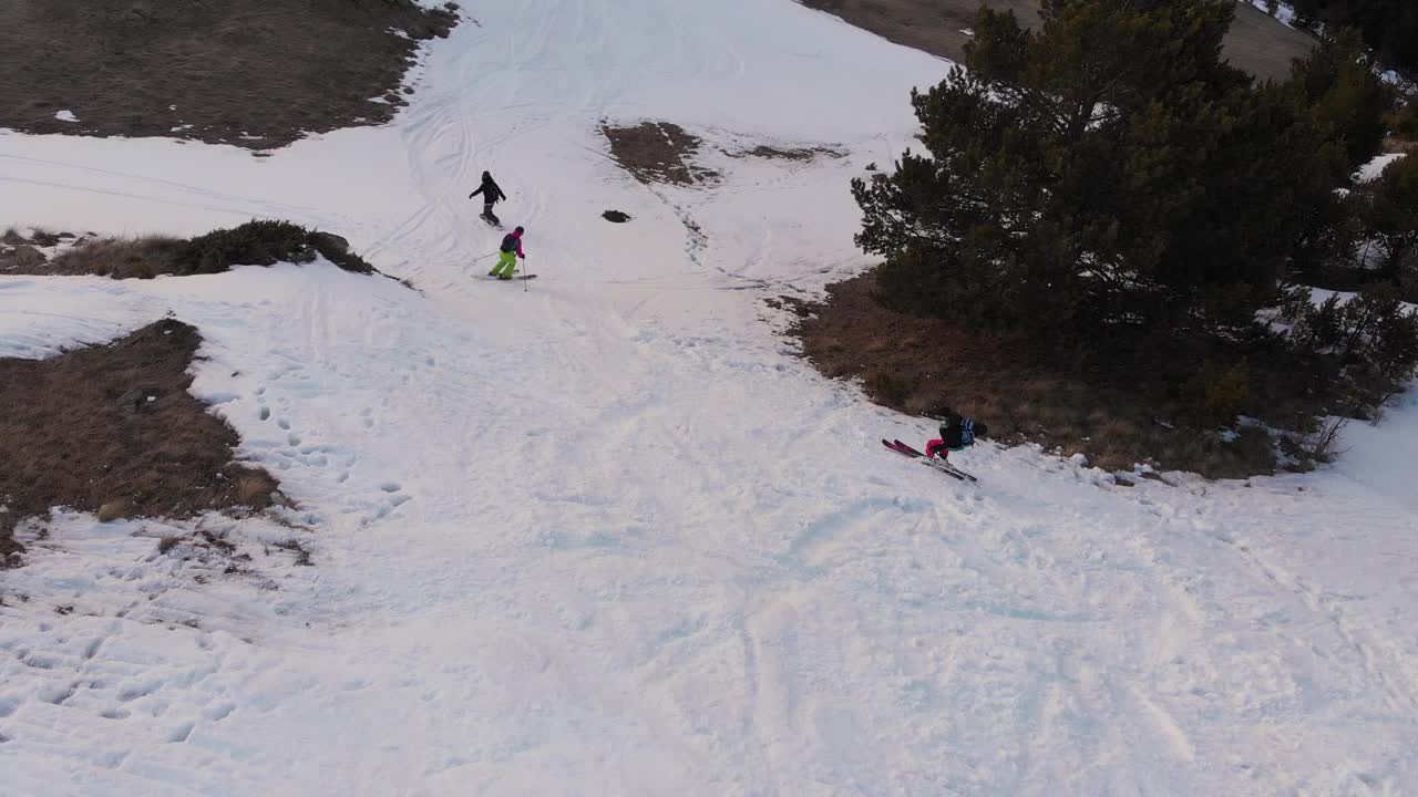 鸟瞰图女运动员公司在滑雪板和滑雪板上走下雪坡在春天。最后的自由骑行，穷乡僻岭视频素材