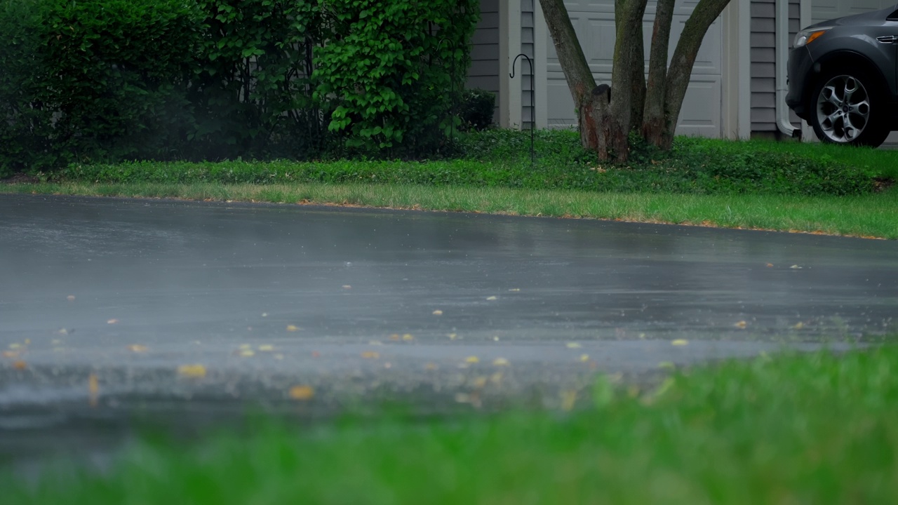 雨后大雾，大雨落在柏油路上的大水坑里，淹没了郊区的街道。放大视图。慢动作视频素材