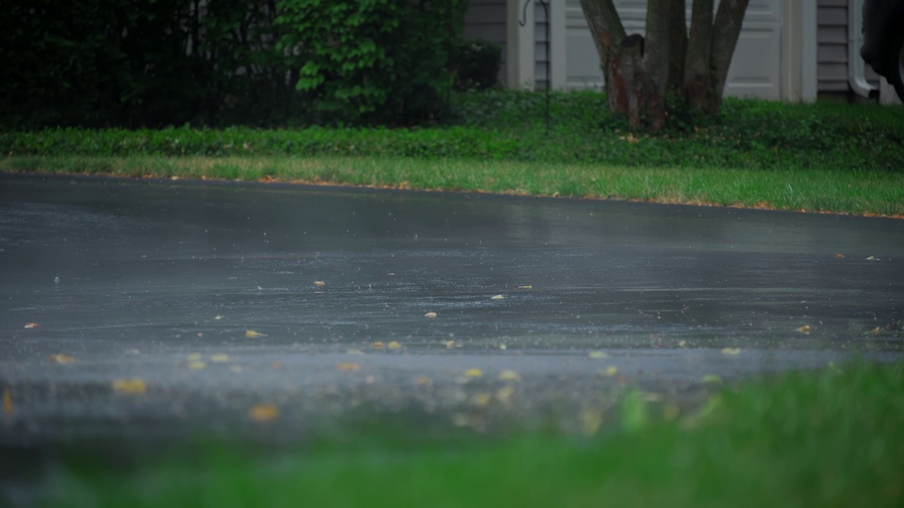 雨后大雾，大雨落在柏油路上的大水坑里，淹没了郊区的街道。放大视图。慢动作镜头视频素材