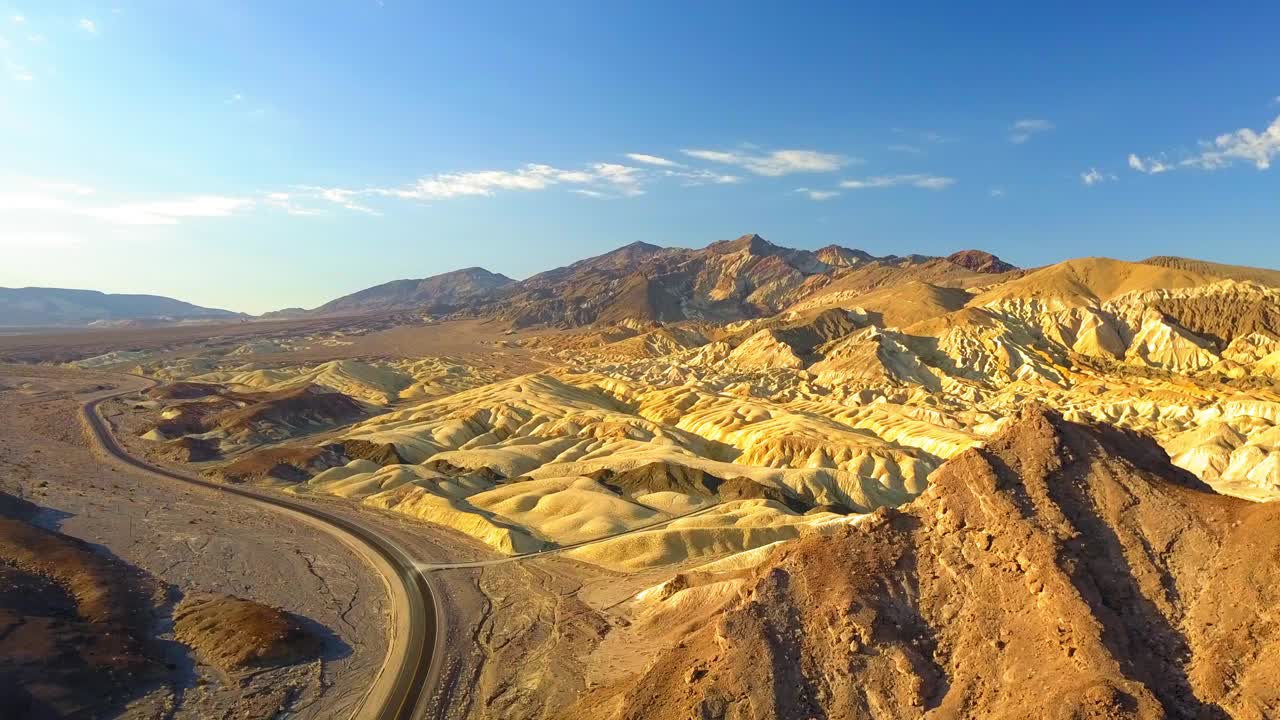 在晴朗的日子里，无人机在蓝天下的岩层空中下降拍摄，飞越景观-死亡谷，加利福尼亚视频素材