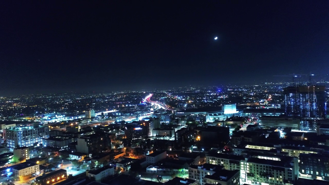 夜间在灯火通明的城市道路上行驶的车辆的空中慢动作镜头，无人机在城市景观上向前飞行-洛杉矶，加利福尼亚视频素材