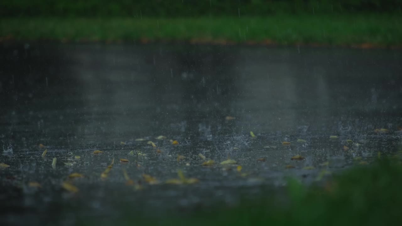 雨后雾的慢动作镜头，大雨落在沥青上的大水坑里，淹没了郊区的街道。放大视图。慢动作镜头视频素材