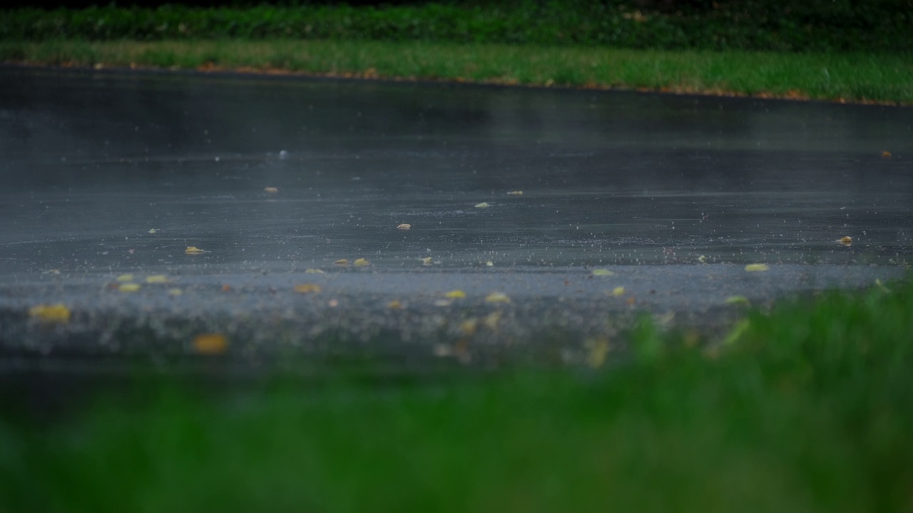 雨后大雾，大雨落在柏油路上的大水坑里，淹没了郊区的街道。放大视图。慢动作镜头视频素材