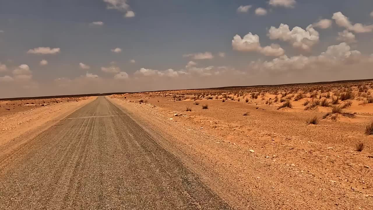 在阳光明媚的日子里，开车穿过突尼斯干旱的风景，司机的视角视频素材