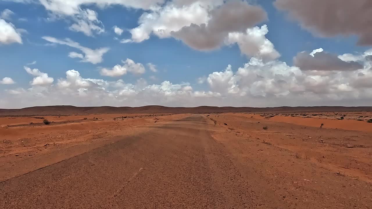 汽车POV行驶在突尼斯沙漠道路上，蓝天白云视频素材