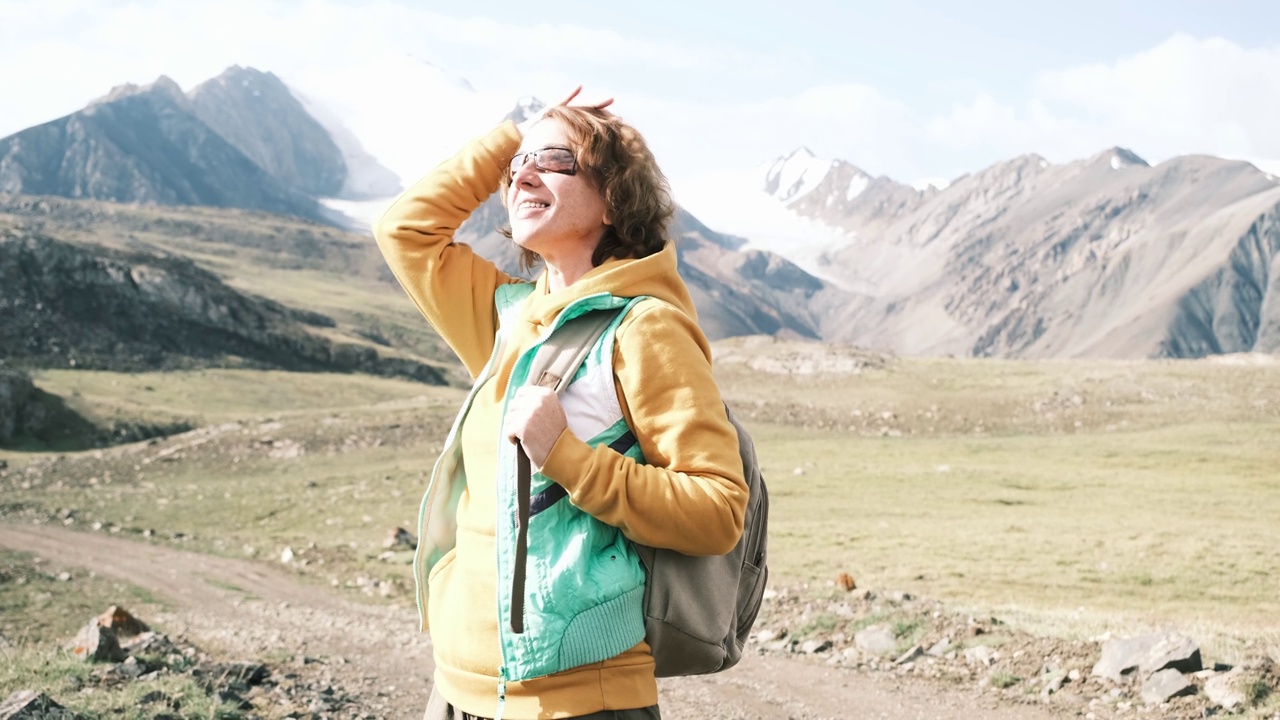 开朗的女游客在山路上看风景视频素材